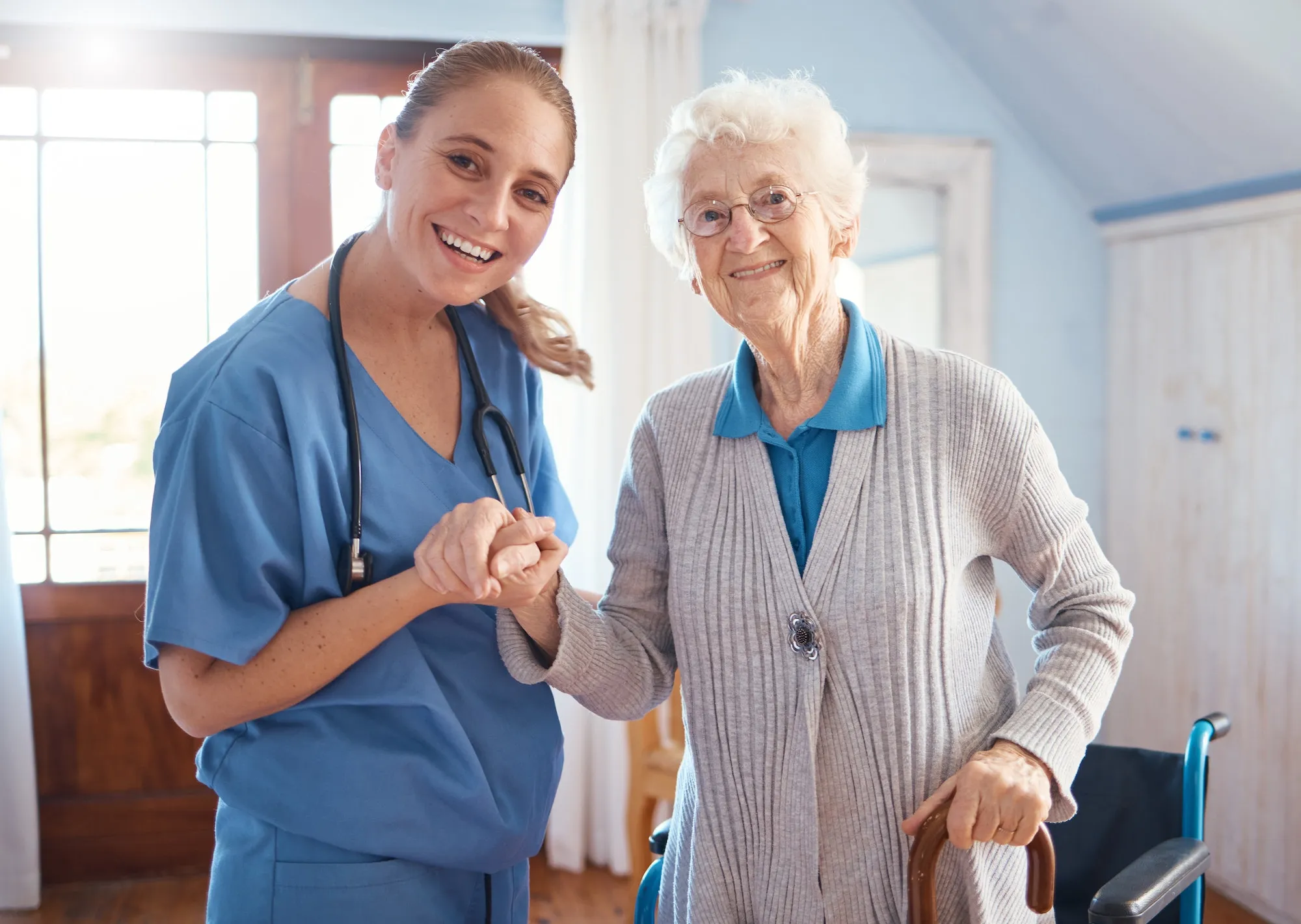 Compassionate caregiver holding hands with senior patient